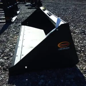 Black metal tractor bucket on gravel.