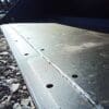Closeup of a metal tractor scoop.