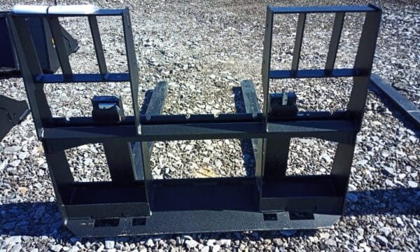 Black metal fork attachment for a skid steer.