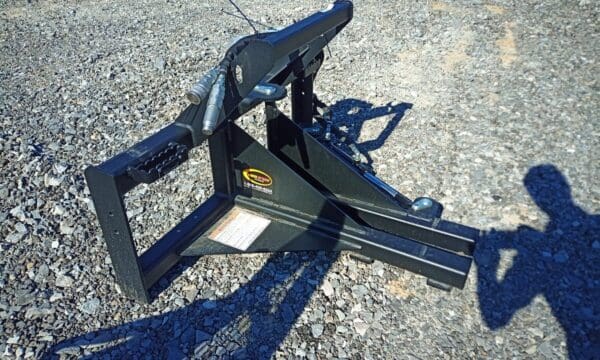 Black metal construction equipment on gravel.