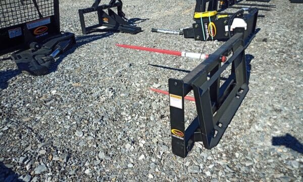 Black metal fork attachment on gravel.