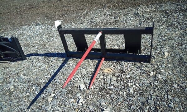 Black metal hay spear with red tines.