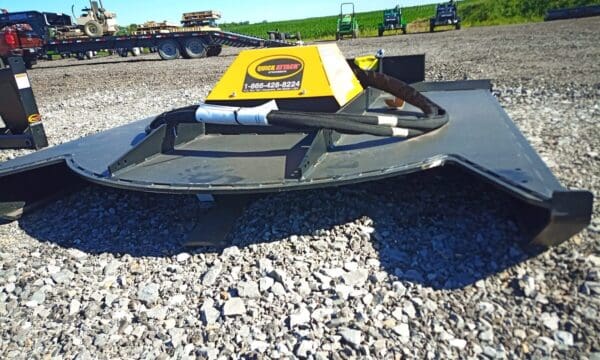 Black brush cutter on gravel ground.