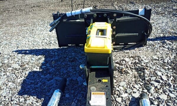 Hydraulic breaker with toolbox on gravel.