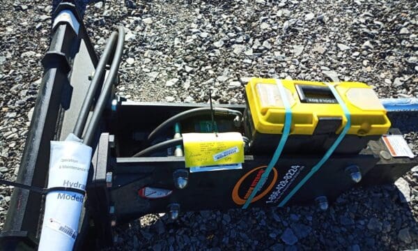 Black hydraulic breaker with yellow toolbox.