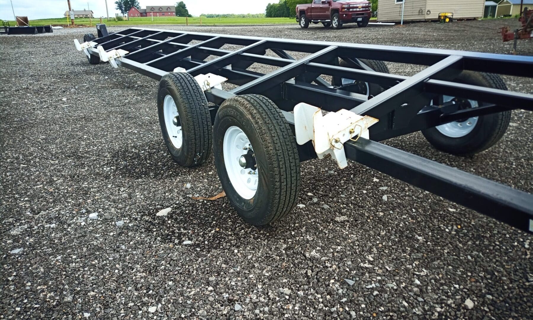 Black utility trailer with white wheels.