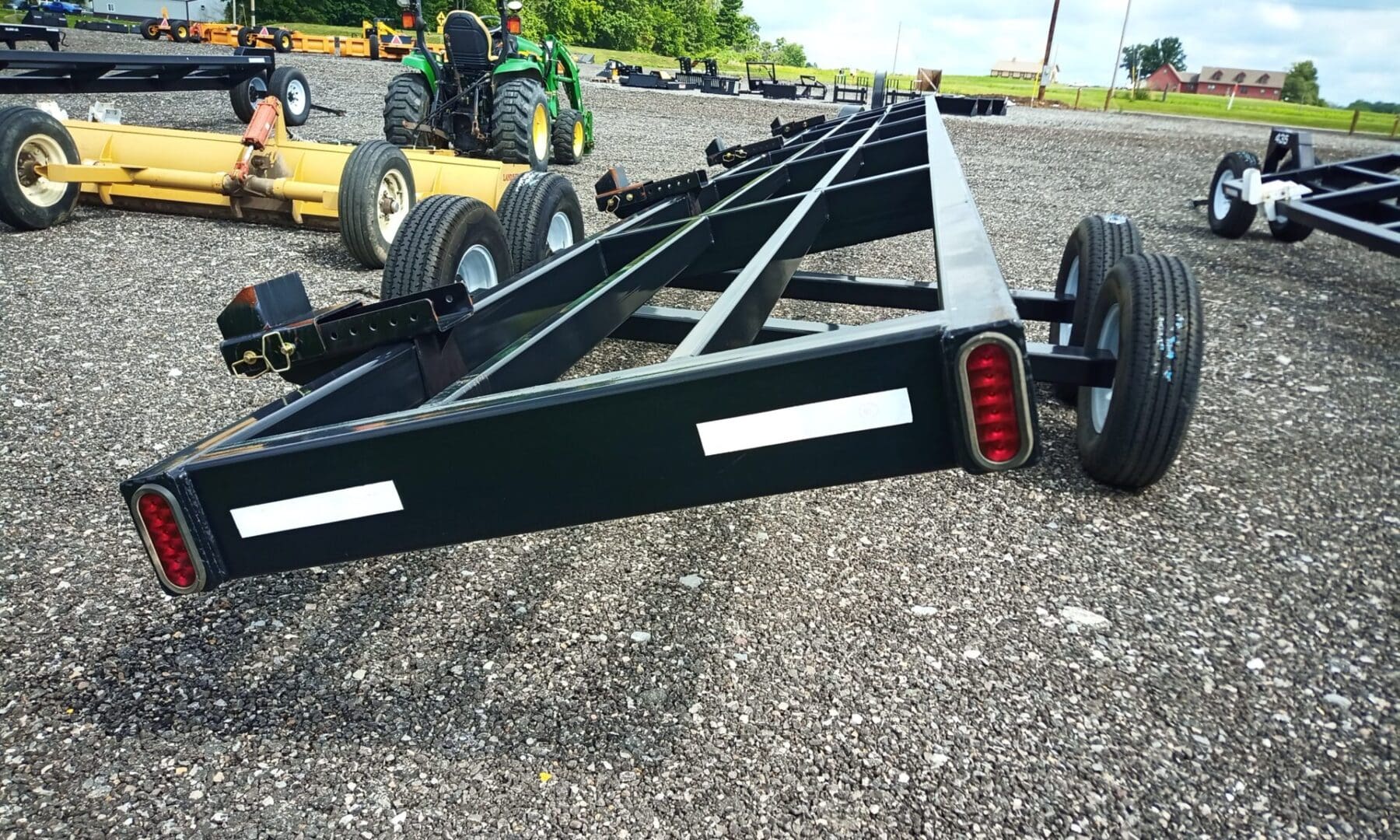 Black trailer with two sets of wheels.