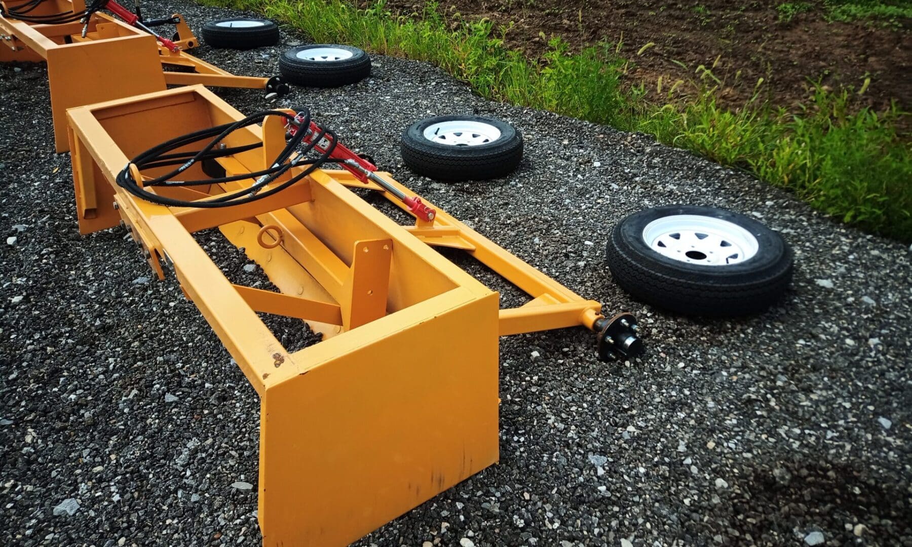 Yellow tractor attachment with wheels.