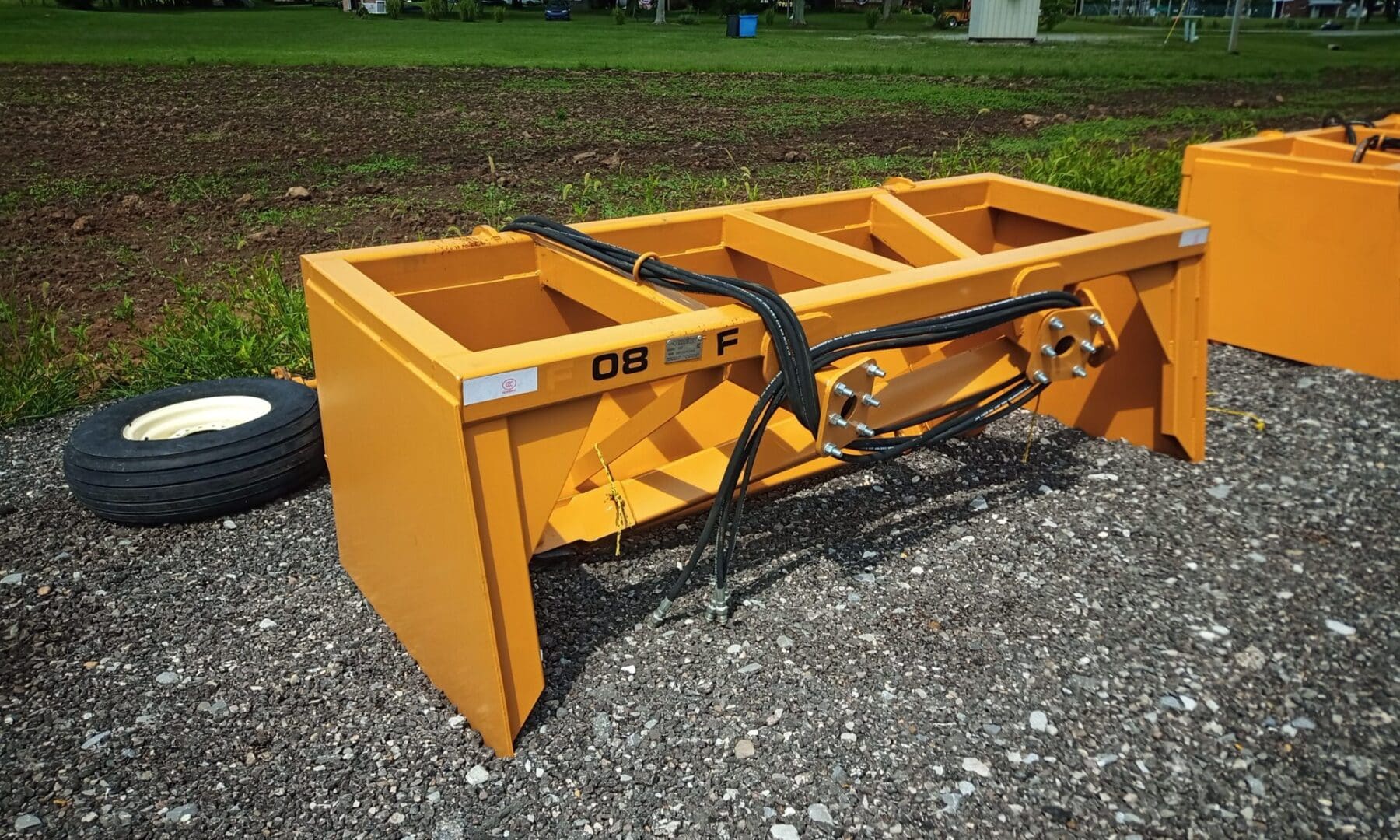 Yellow farm equipment with a tire.