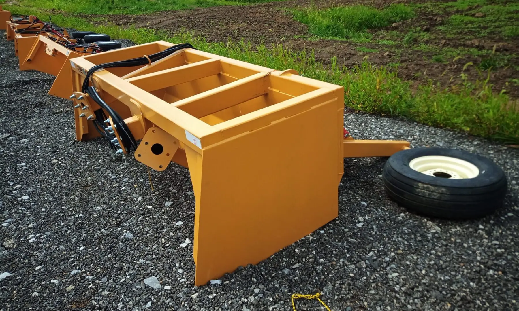 Yellow farm equipment with one wheel.