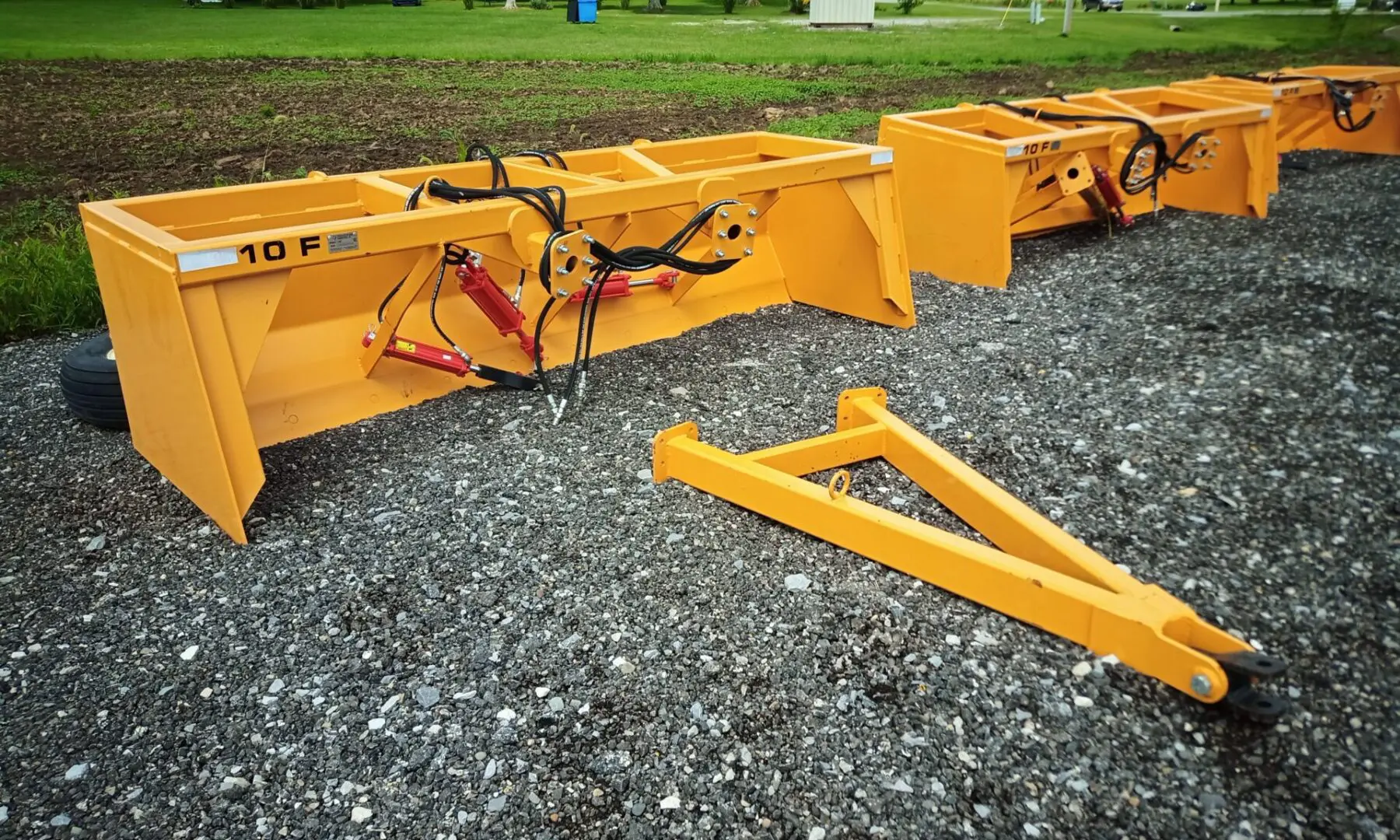 Yellow tractor snow plow attachment.