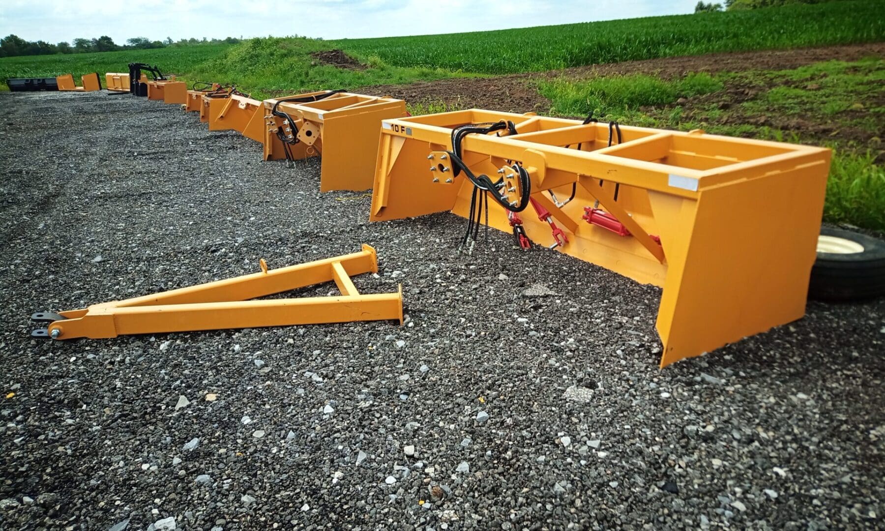 Yellow farm equipment on gravel.