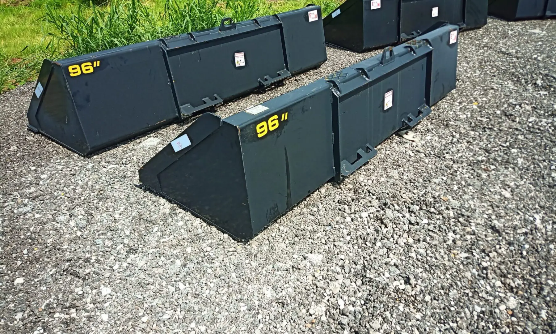 Black tractor buckets on gravel