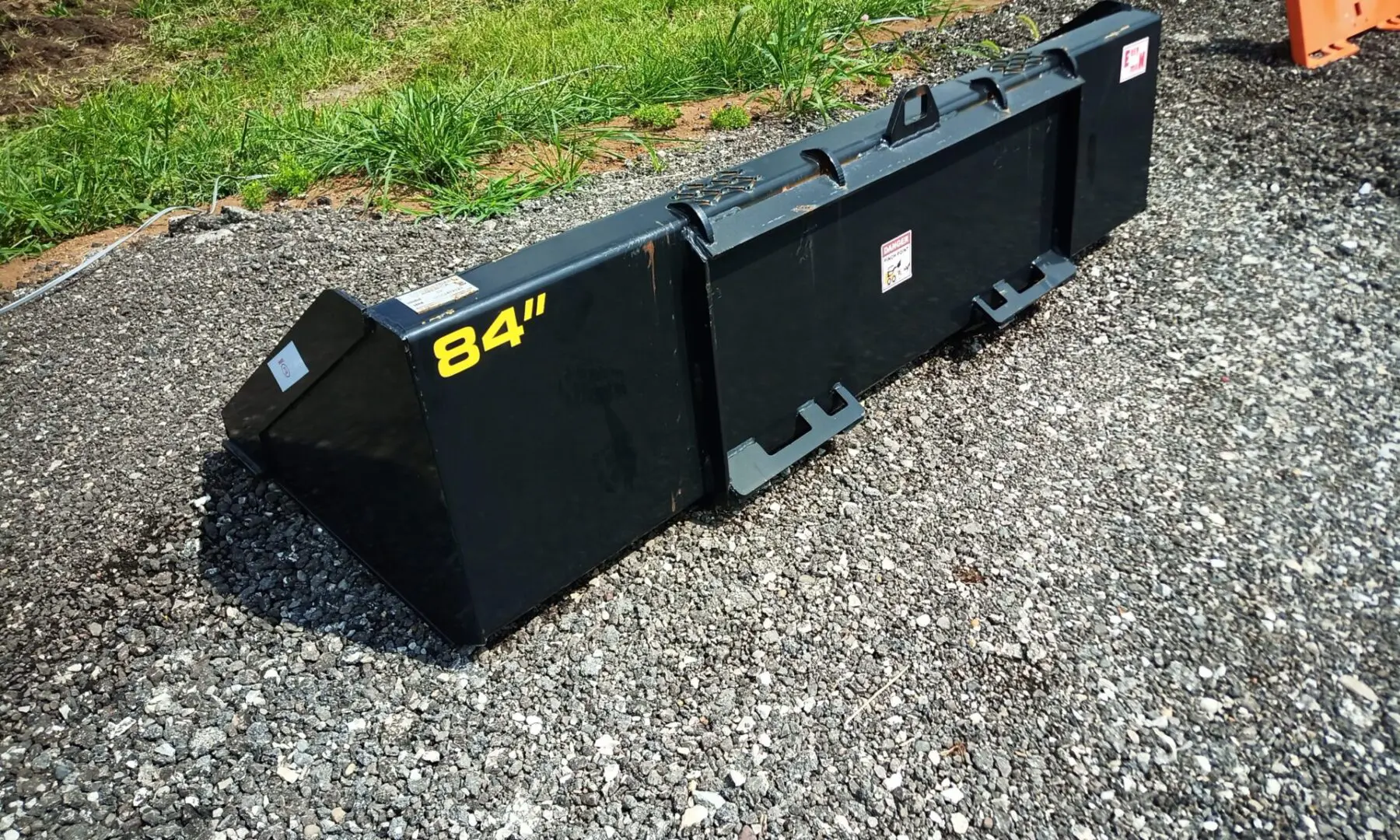 Black 84 inch skid steer bucket.