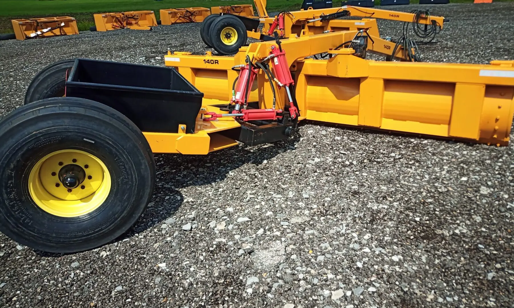 Yellow snow plow with black box and tires.