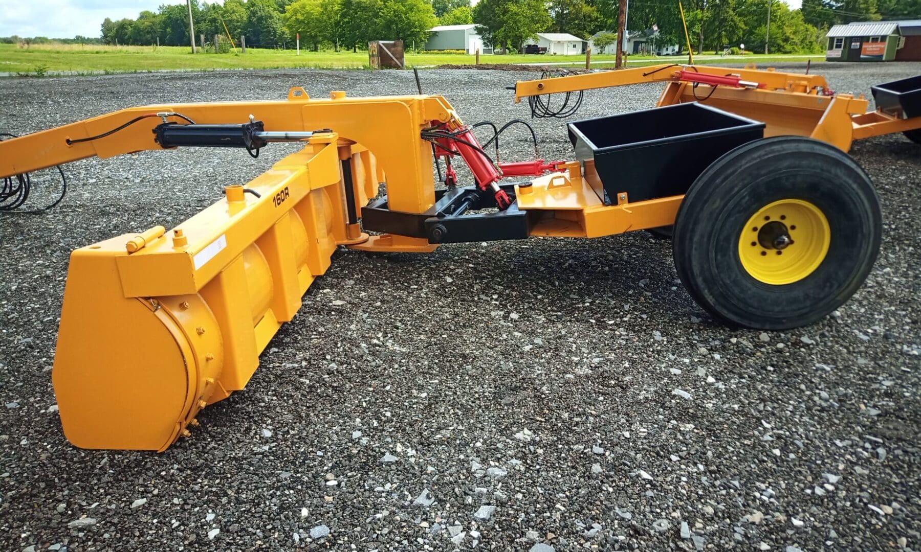 Yellow snow plow with large tires.