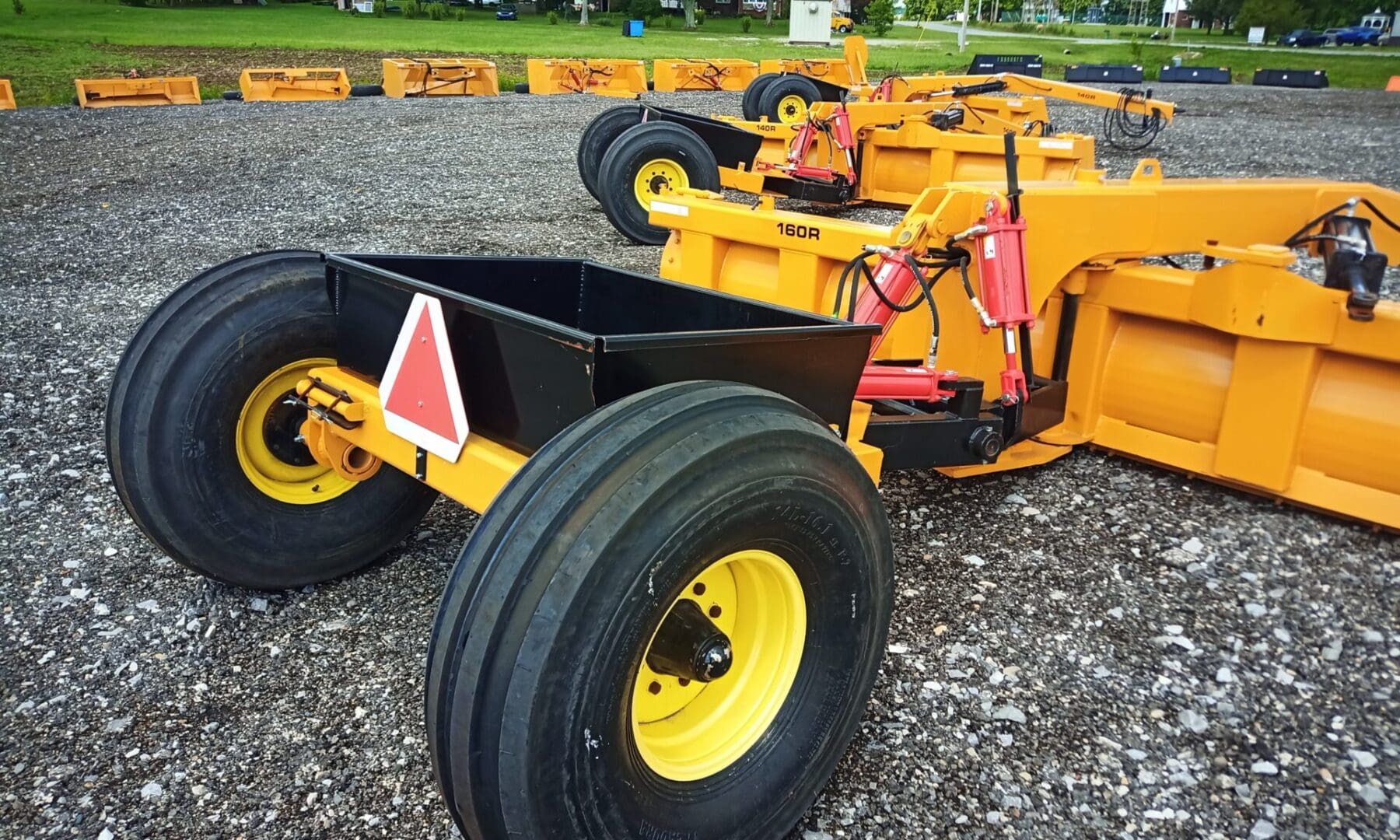 Yellow farm tractor with snow plow attachment.