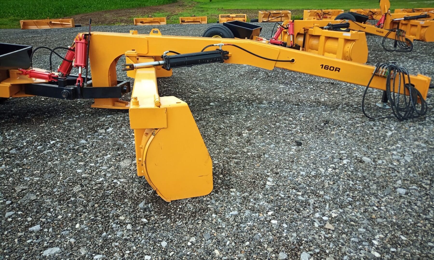 Yellow 160R snow plow on gravel.