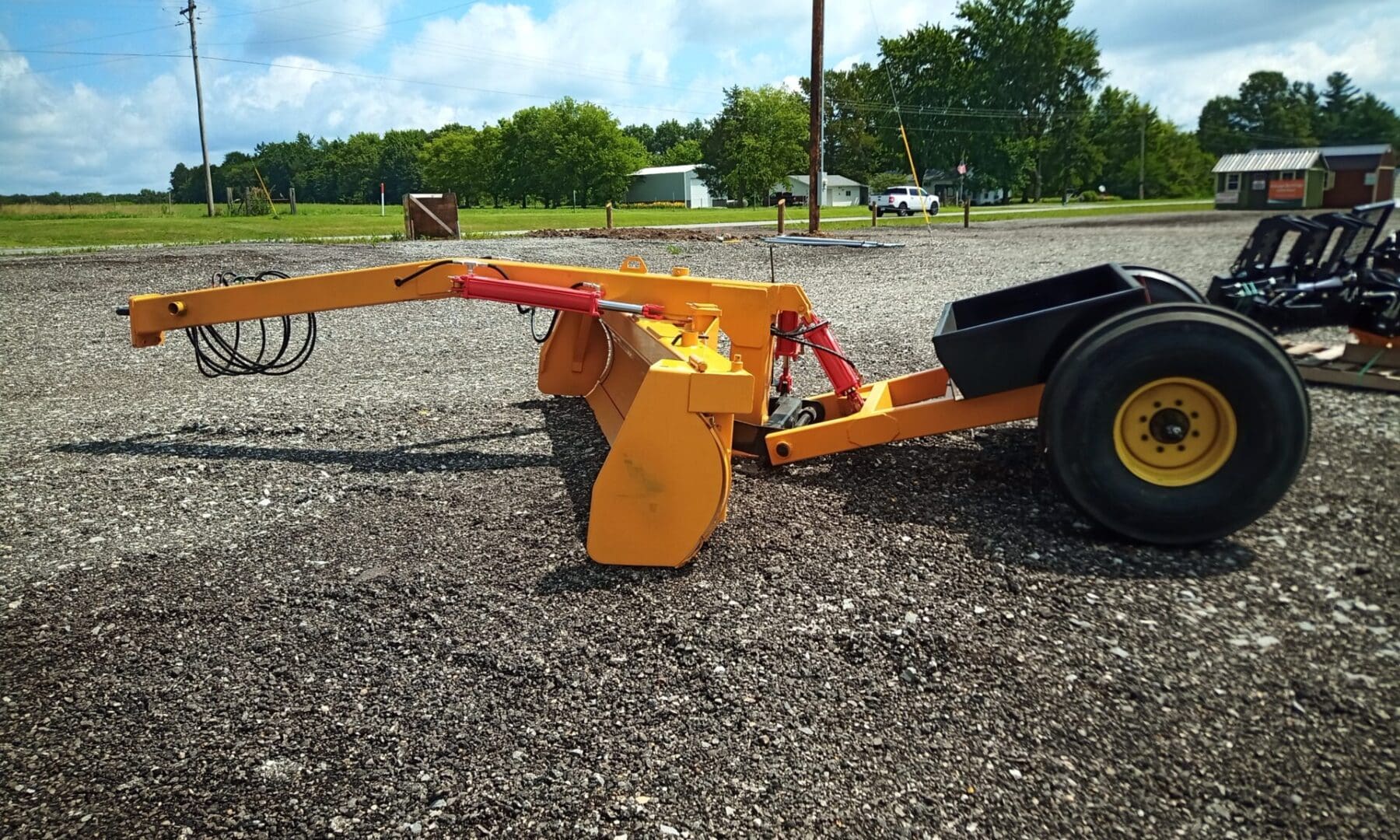 Yellow and black farm equipment on gravel.