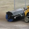 Skid steer sweeping with a rotary broom.
