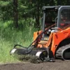 Orange track loader clearing land.