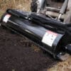 Here's an 8-word alt tag for the image: Black land leveler smoothing soil, attached to tractor.
