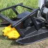Black land clearing attachment with yellow blades.