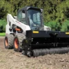 Skid steer with land leveler attachment.