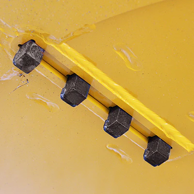 Here's an alt tag for the image: Four black blocks on yellow surface.