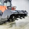 Here's an alt tag for the image: Skid steer with rotary cutter attachment.