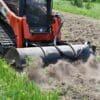 Tracked skid steer clearing land.