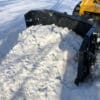 Snow removal with a skid steer bucket.