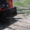 Skid steer with pallet forks attached.