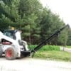White skid steer lifting a long beam.