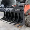 Here's an alt tag for the image: Black grapple rake attached to excavator.