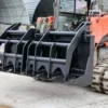 Here's an alt tag for the image: Black grapple attachment for skid steer loader.