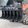 Here's an alt tag for the image: Black rock grapple attached to a skid steer.